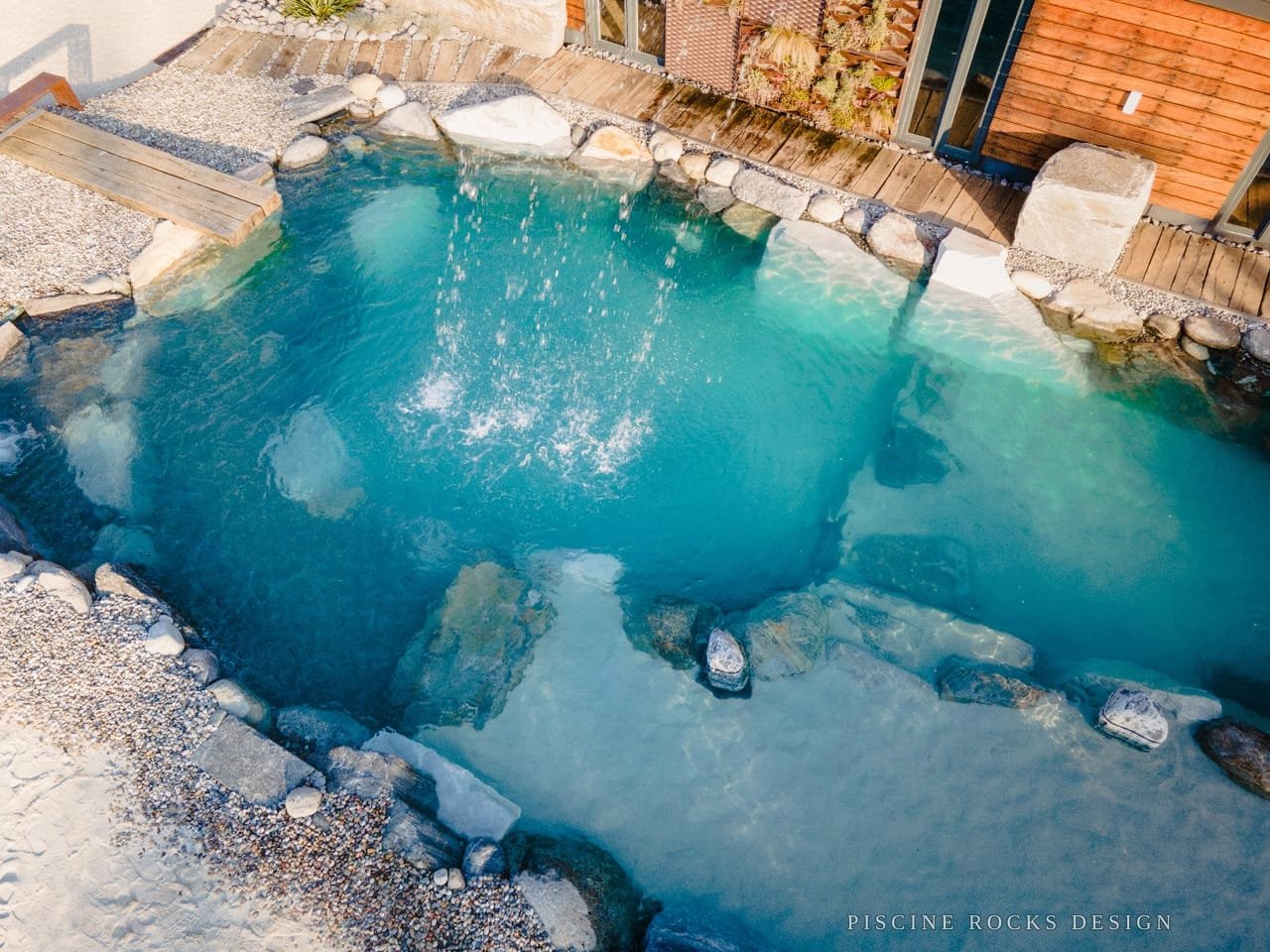 Area idromassaggio di una piscina Rocks Design con acqua turchese