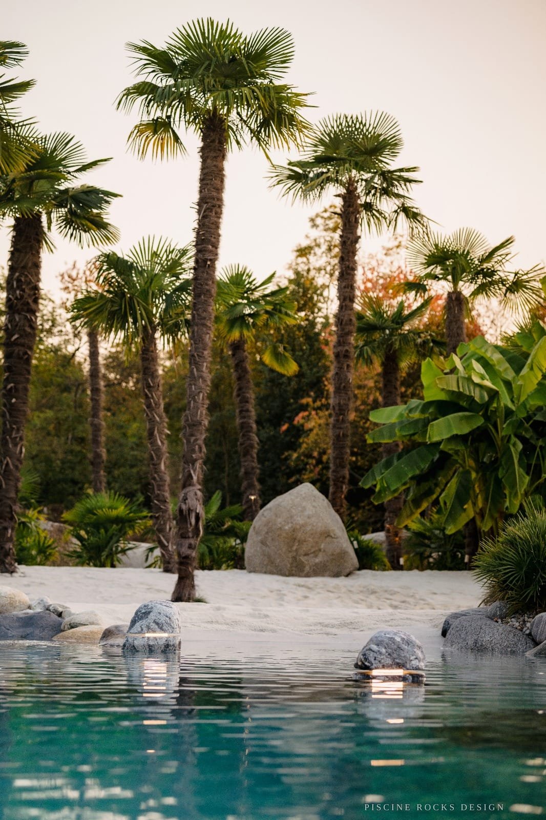 Palme e massi monolitici attorno a una piscina Rocks Design