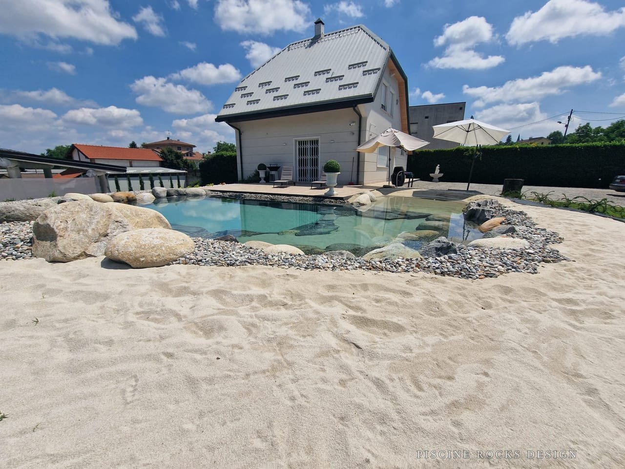 Piscina Rocks Design con un’ampia spiaggia di sabbia davanti alla casa